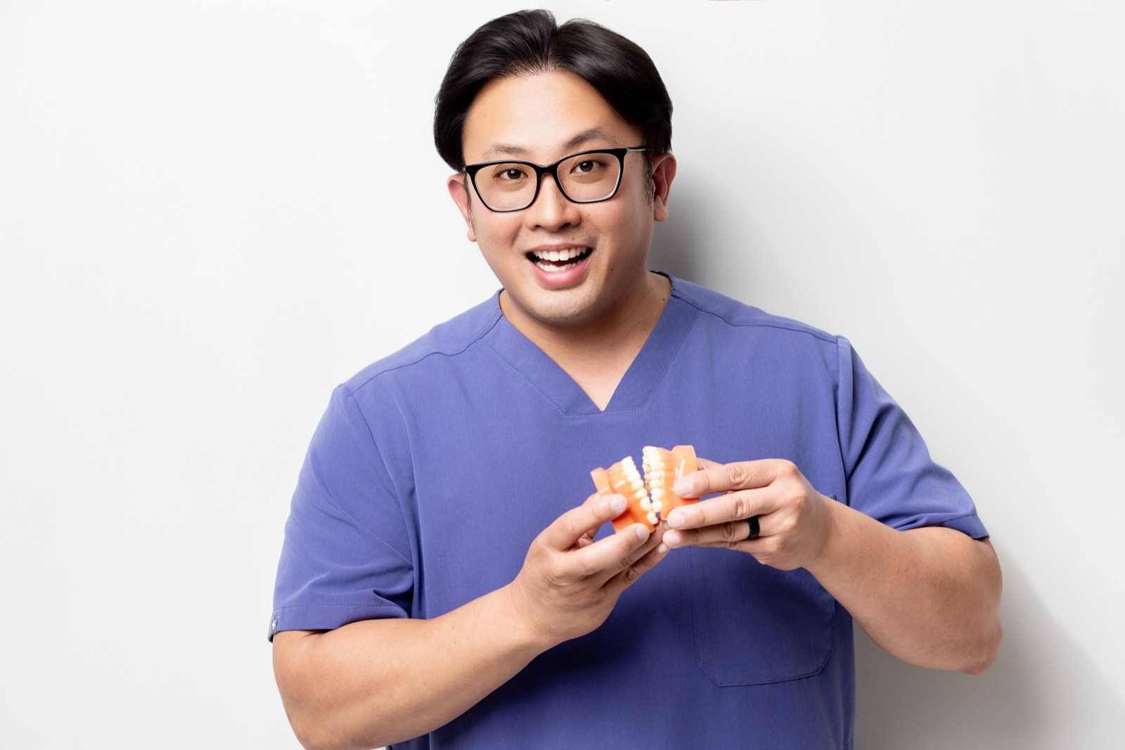 Dr. Vu D. Tran holding a dental model while explaining bite alignment